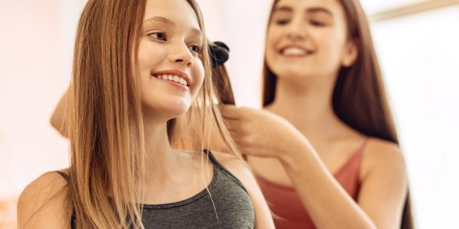 Prostowanie włósów prostownicą.